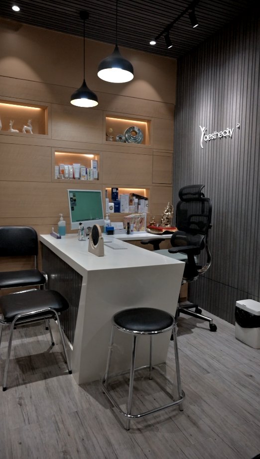 Doctor’s cabin with consultation desk and Aesthecity logo wall