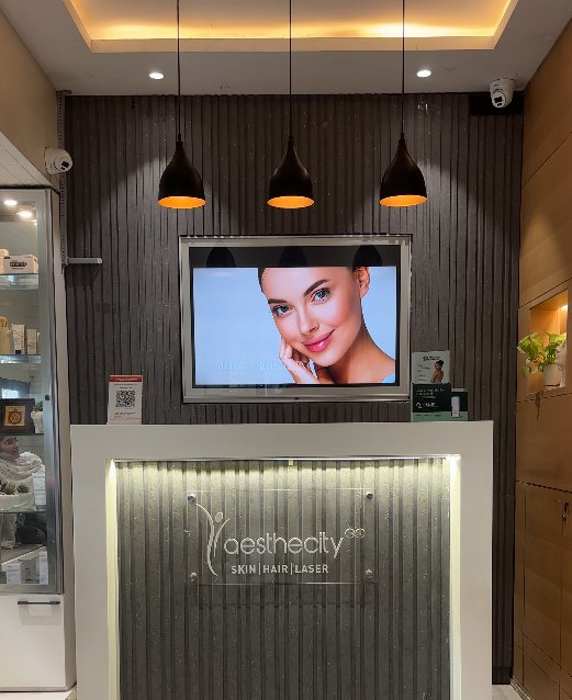Aesthecity reception desk with logo wall and display screen